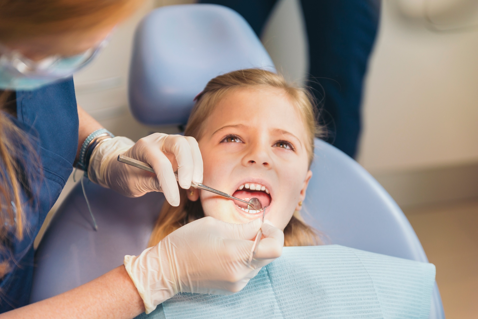 dentists-with-a-patient-during-a-dental-intervention-to-girl-.jpg