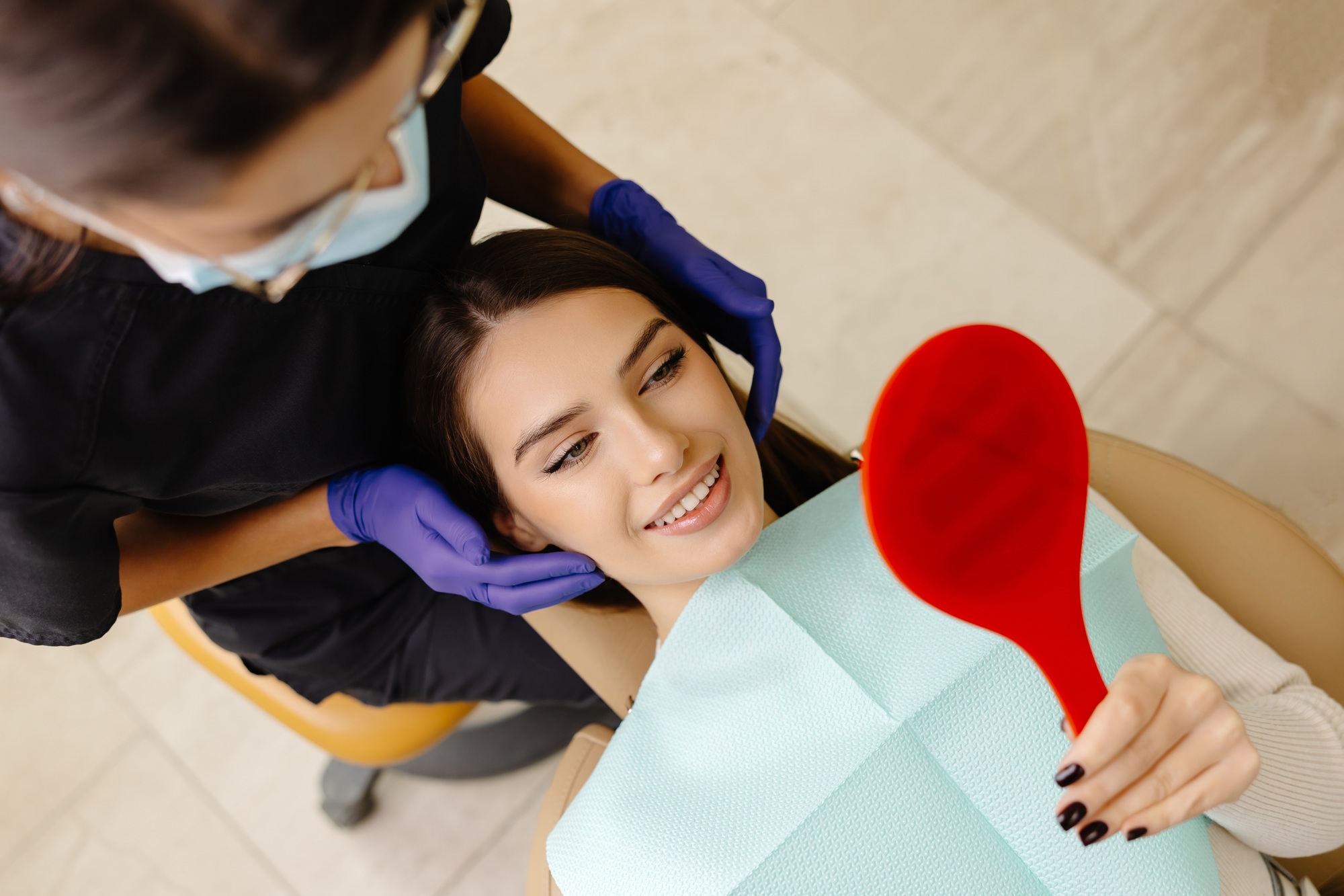 the-dentist-checks-the-patient-s-condition-by-touching-her-head.jpg